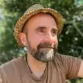 Cyrille sourit avec un chapeau de paille